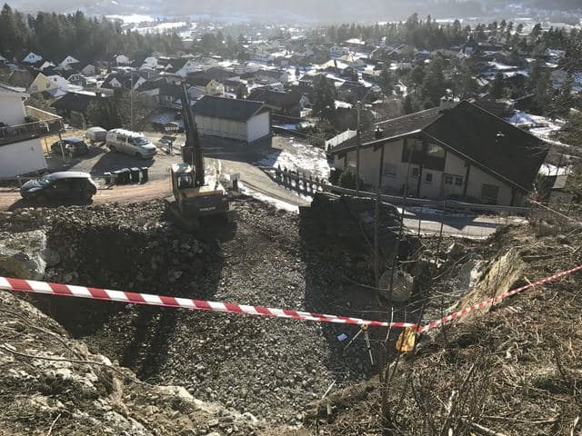 Byggegrop i et boligfelt sett ovenfra, med gravemaskin og sperrebånd.
